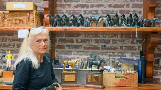 Julie Short Rinaldini poses with the Eclipse Awards statues she crafts by hand