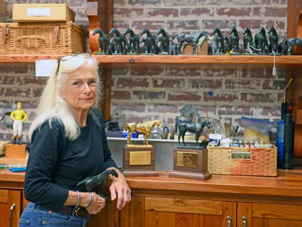 Julie Short Rinaldini poses with the Eclipse Awards statues she crafts by hand